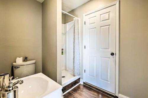 a bathroom with a sink and a toilet and a door at Modest Huntsville Studio with Full Kitchen! in Huntsville