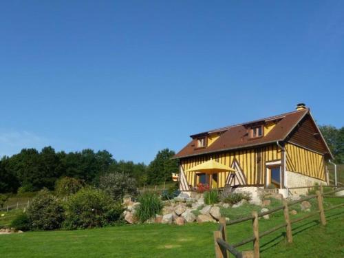 uma casa de madeira com uma cerca num campo em Domaine du Martinaa em Saint-Martin-de-la-Lieue