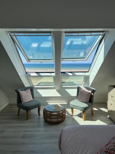 Habitación con 2 sillas, 1 cama y 1 mesa en Les Chambres d'Hôtes de la Mer, en Merlimont-Plage