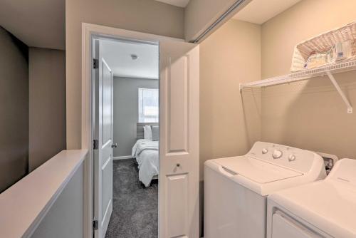 a bathroom with a washer and dryer next to a bedroom at Airy Tallahassee Condo about 5 Mi to Downtown! in Tallahassee