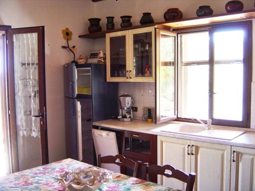 a kitchen with a sink and a refrigerator at La Finestra sulle Eolie in Reitano