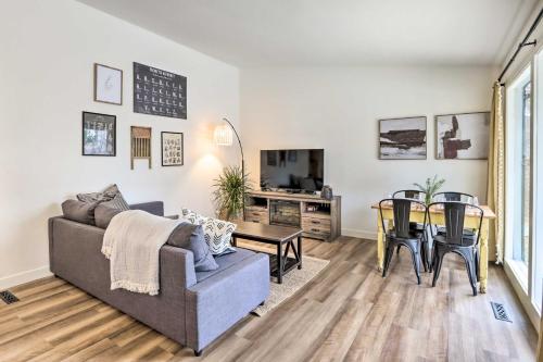 a living room with a couch and a table at Cottage with Grill and Fire Pit in Osage Beach! in Osage Beach