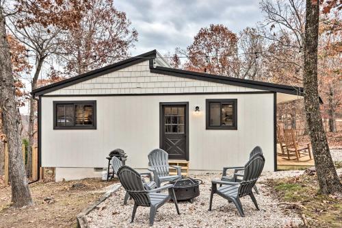 a group of chairs sitting in front of a house at Cottage with Grill and Fire Pit in Osage Beach! in Osage Beach