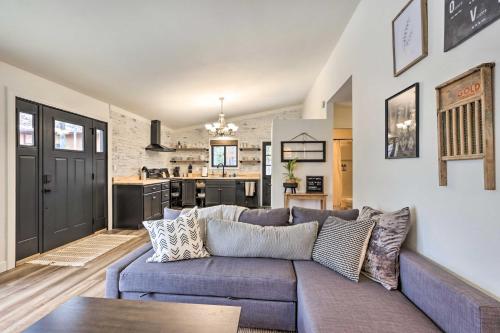 a living room with a couch and a kitchen at Cottage with Grill and Fire Pit in Osage Beach! in Osage Beach
