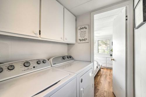 una cocina con armarios blancos y electrodomésticos blancos en New Concord Lake House with Dock and Boat Slip!, en New Concord