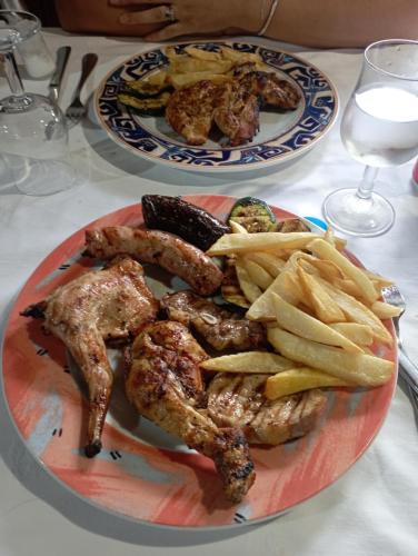 two plates of food with meat and french fries on a table at Moderno in Barcelona