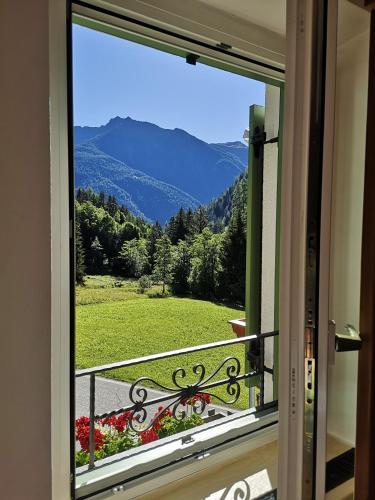 a window with a view of a mountain view at Hotel Villa Milano in Peio Fonti