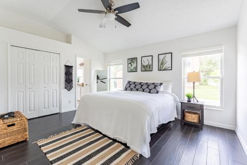 a white bedroom with a bed and a ceiling fan at East Orlando Getaway - 3BR/2BTH - *Pool *Parking in Orlando