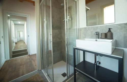 a bathroom with a sink and a glass shower at FORESTERIA LOMBARDA BED and BIKE CREMONA 