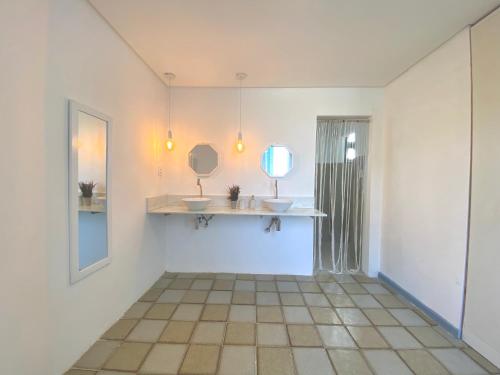 a bathroom with two sinks and a mirror on the wall at Exclusiva Casa na Melhor Praia de Aracaju in Aracaju