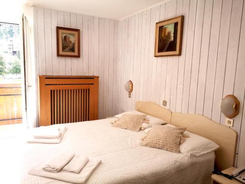 ペーイオ・フォンティにあるHotel Villa Milanoのベッドルーム1室(白いベッド1台、タオル付)