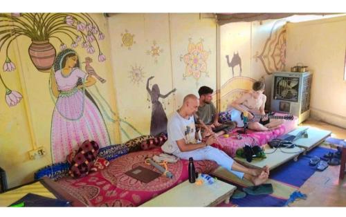 a group of people sitting in a room with a mural at Hotel Desert in Jaisalmer