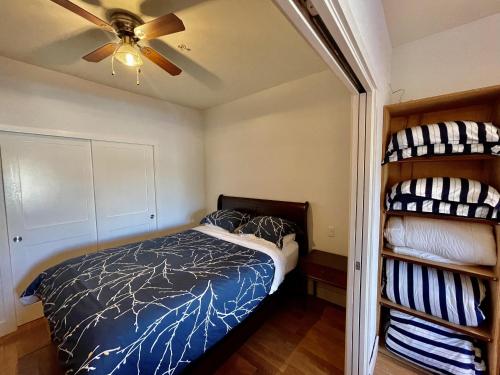1 dormitorio con 1 cama y ventilador de techo en Marina View On The Harbour en Ucluelet