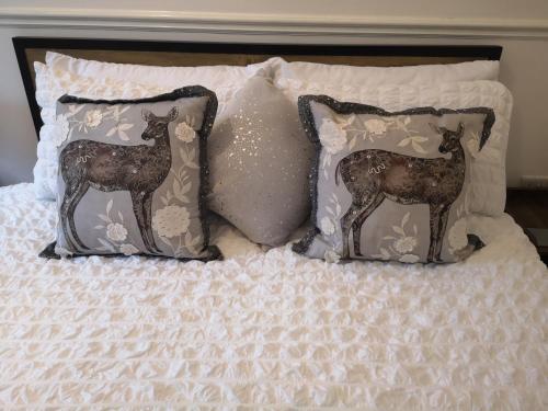 a bed with pillows with deer pillows on it at 34 One in Lytham St Annes