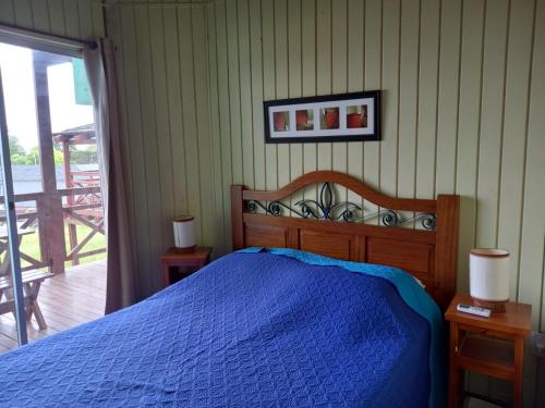 a bedroom with a bed with a blue comforter at Paso del.Sol in Piriápolis