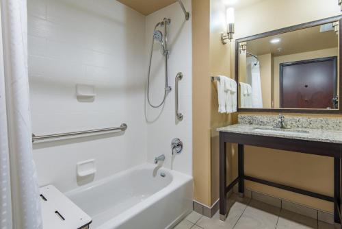 un baño con bañera y lavabo en Holiday Inn Salina by IHG, en Salina