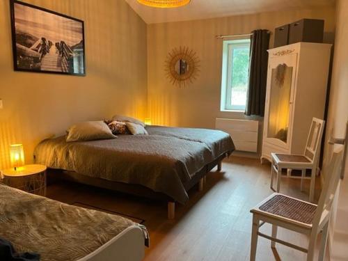 Sainte-Hélène的住宿－O20 Esprit Nature，卧室配有床、椅子和窗户。