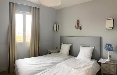 sypialnia z łóżkiem z białą pościelą i oknem w obiekcie Presqu île de la touques deauville N 3404 w mieście Deauville