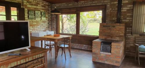 a living room with a table and a fireplace at Loft no campo próximo ao Vale dos Vinhedos in Garibaldi