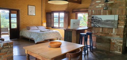 ein Schlafzimmer mit einem Bett und einem Tisch in einem Zimmer in der Unterkunft Loft no campo próximo ao Vale dos Vinhedos in Garibaldi