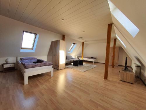 a large room with a bed and a desk in a attic at Nice holiday apartment close to the center in Wilhelmshaven in Wilhelmshaven
