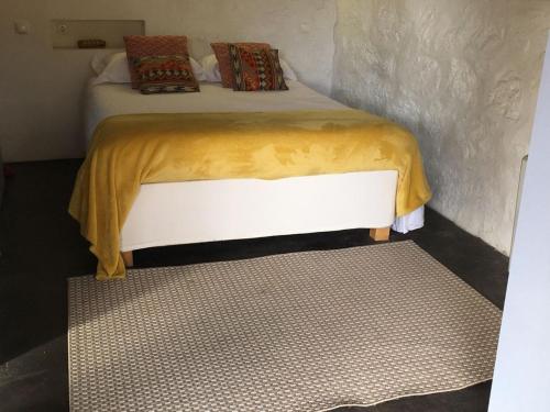 um quarto com uma cama com um cobertor amarelo em Casa da Eira - Sobrenatura Ecoturismo em Arcos de Valdevez