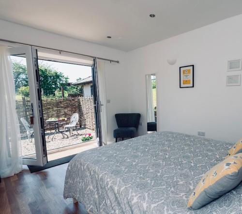 a bedroom with a bed and a sliding glass door at Rossendale Holiday Cottages & Spa in Rossendale