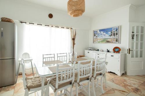 a kitchen with a table and chairs and a refrigerator at TMO Residence 2 in Ponta Delgada