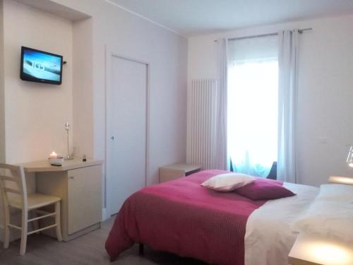 a bedroom with a bed and a desk and a television at B&B Valle Gio' in Magliano deʼ Marsi