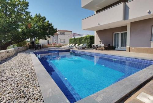 a swimming pool in the backyard of a house at Villa Marija with private heated pool in Podstrana