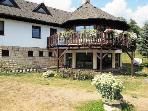 a house with a balcony with flowers on it at Horská chalupa Izerina in Zlatá Olešnice