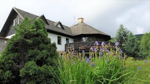 a house with purple flowers in front of it at Horská chalupa Izerina in Zlatá Olešnice