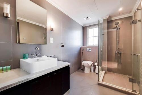 a bathroom with a sink and a shower and a toilet at Whispering Pines, JGE - Vacationer in Dubai
