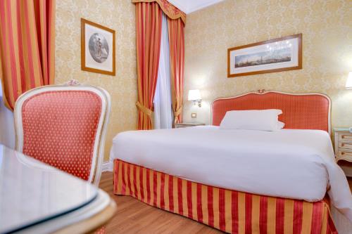 a hotel room with a large bed and two chairs at Hotel Antiche Figure in Venice