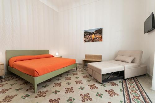 a bedroom with a bed and a chair at Casa Melina in Scicli