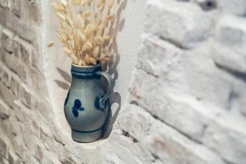 a vase on a wall with a bunch of wheat in it at Aktivhotel Wildschütz in Gmunden
