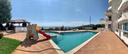 a swimming pool with a slide next to a house at Lilo in Dobra Voda