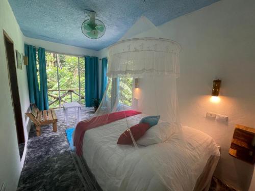 a bedroom with a white bed with a canopy at Salvaje Rooms&Restaurant in Santa Bárbara de Samaná