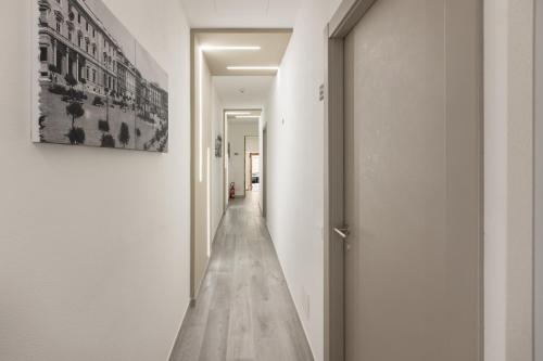 a hallway with white walls and a wooden floor at DELEDDA HOME in Cagliari