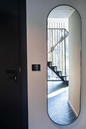 a mirror on a wall next to a staircase at Hotel Čad in Ljubljana