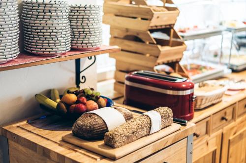 a kitchen counter with fruits and vegetables on a cutting board at Aktivhotel Wildschütz in Gmunden