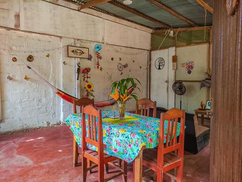 a dining room with a table and chairs with a vase on it at ROSA'S HOUSE in Puerto Maldonado