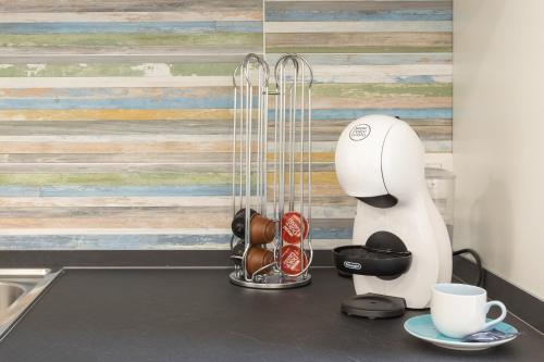 a kitchen counter with a coffee maker and cups at DELEDDA HOME in Cagliari