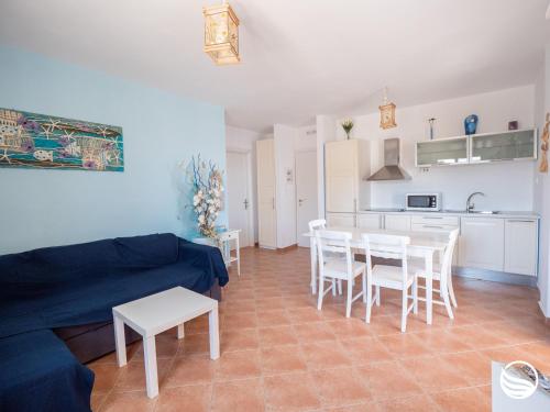 - un salon avec un canapé bleu, une table et des chaises dans l'établissement Sogno Greco, à Elafonisos