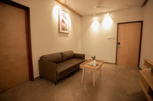a living room with a couch and a table at HILUX COURTYARD in Palakkad