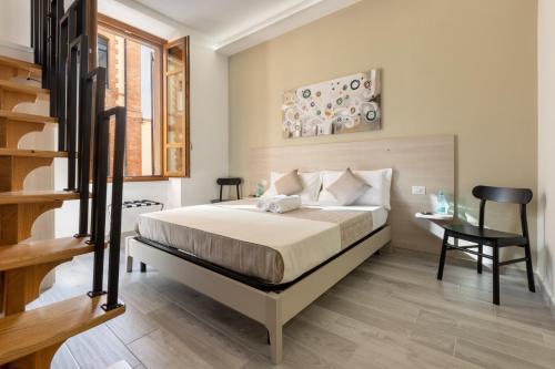 a bedroom with a bed and a desk and a staircase at DELEDDA HOME in Cagliari