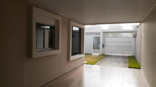 an empty hallway with a white door and a garage at Casa térrea para família no centro de Ametista! in Ametista do Sul