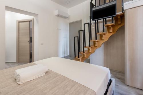 a bedroom with a bed and a staircase at DELEDDA HOME in Cagliari