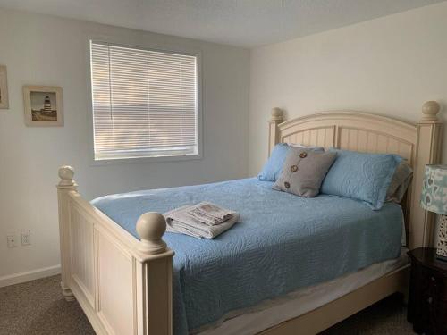 um quarto com uma cama com lençóis azuis e uma janela em Minutes to the beach! 4-bedroom home, free parking em Hampton
