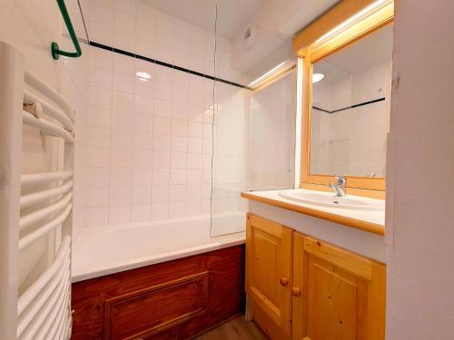 a bathroom with a sink and a tub and a mirror at Appartement 2 pièces ski aux pieds avec balcon - 4 personnes - FR-1-344-940 in Les Bruyères